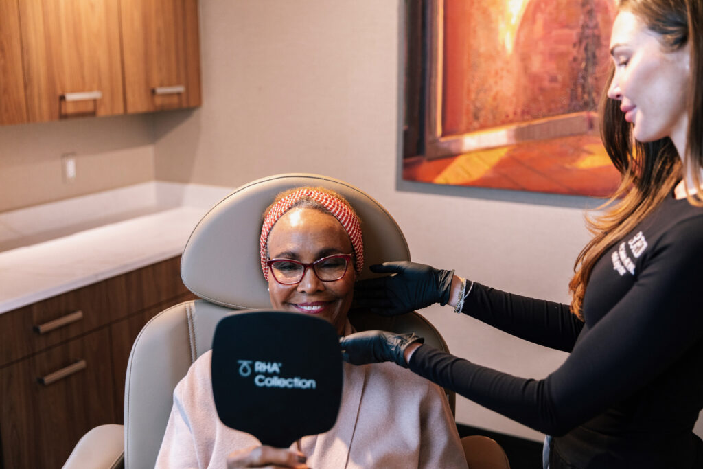Jordan Carlesimo, RN aesthetic injector at BOYD Med Spa, reviewing dermal filler results with a patient in Metro Detroit